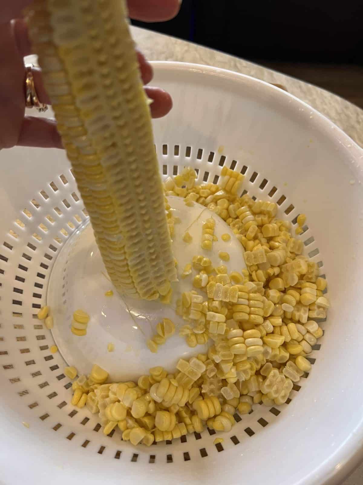 Taking the kernals off ears of corn