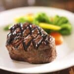 Seared steak on a white plate