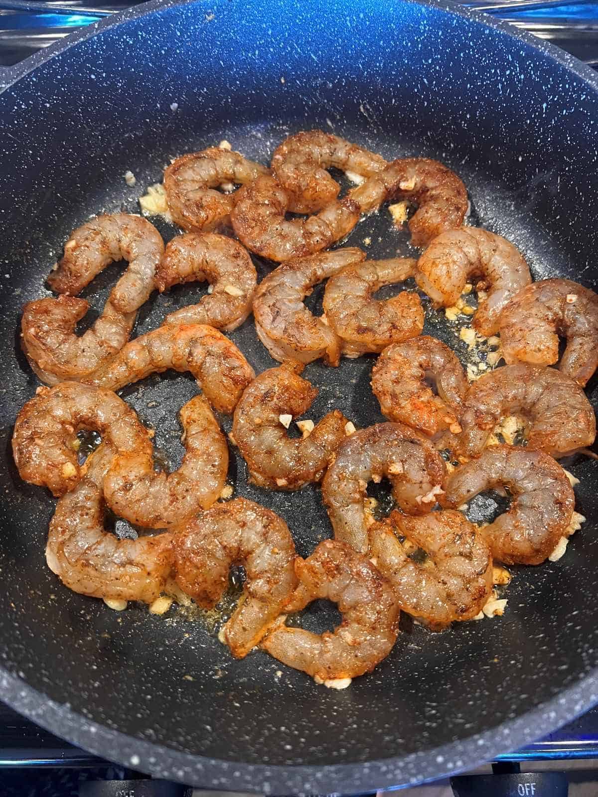 shrimp tossed in garlic butter in the skillet
