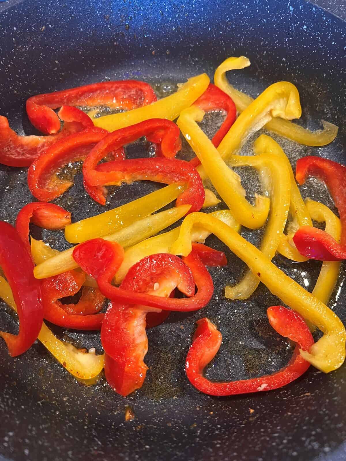 red and yellow pepper slices in a skillet