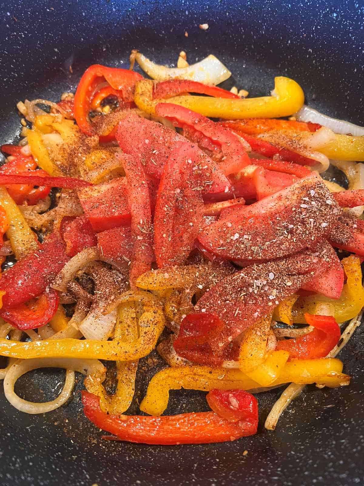 cooked peppers and onions with Roma tomatoes and seasoning mix