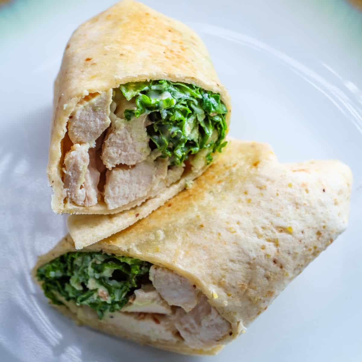 Chicken Caesar Wrap cut in half on a white plate