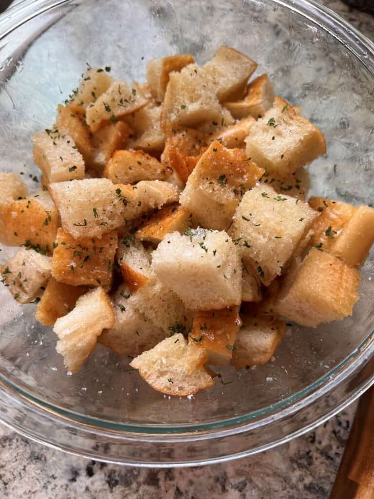 Buttered bread cubes in a clear bowl