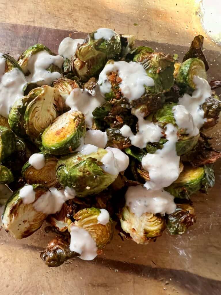 Drizzle Caesar dressing on top of the sprouts