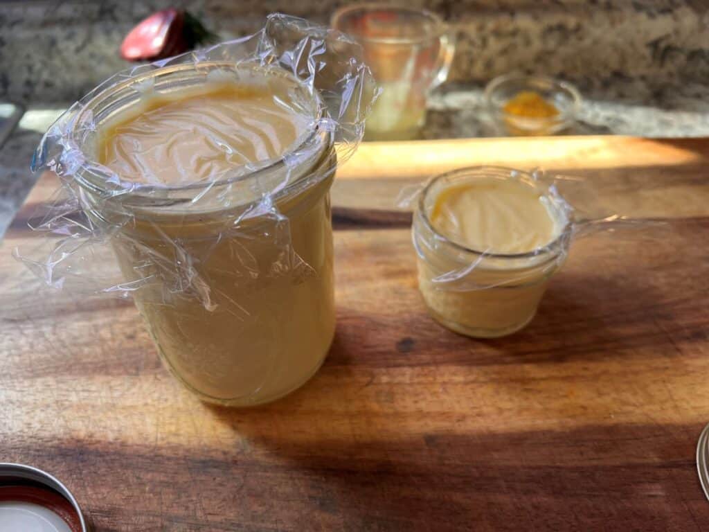 Lemon curd in mason jars with platic wrap on the top