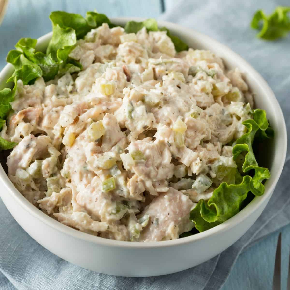 Chicken Salad in a white bowl with lettuce
