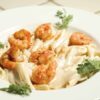 Finished garlicky shrimp alfredo bake recipe in a white bowl