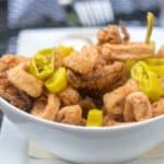 Fried calamari in a white bowl with garlic butter and peppers