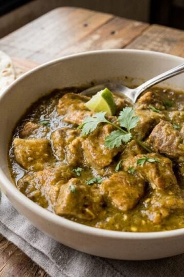 A white bowl full of hatch green chile pork stew