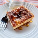 finished slice of sopapilla cheesecake on a white plate drizzled with honey