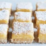 Lemon Gooey Butter Cake cut into bars and sprinkled with powdered sugar.
