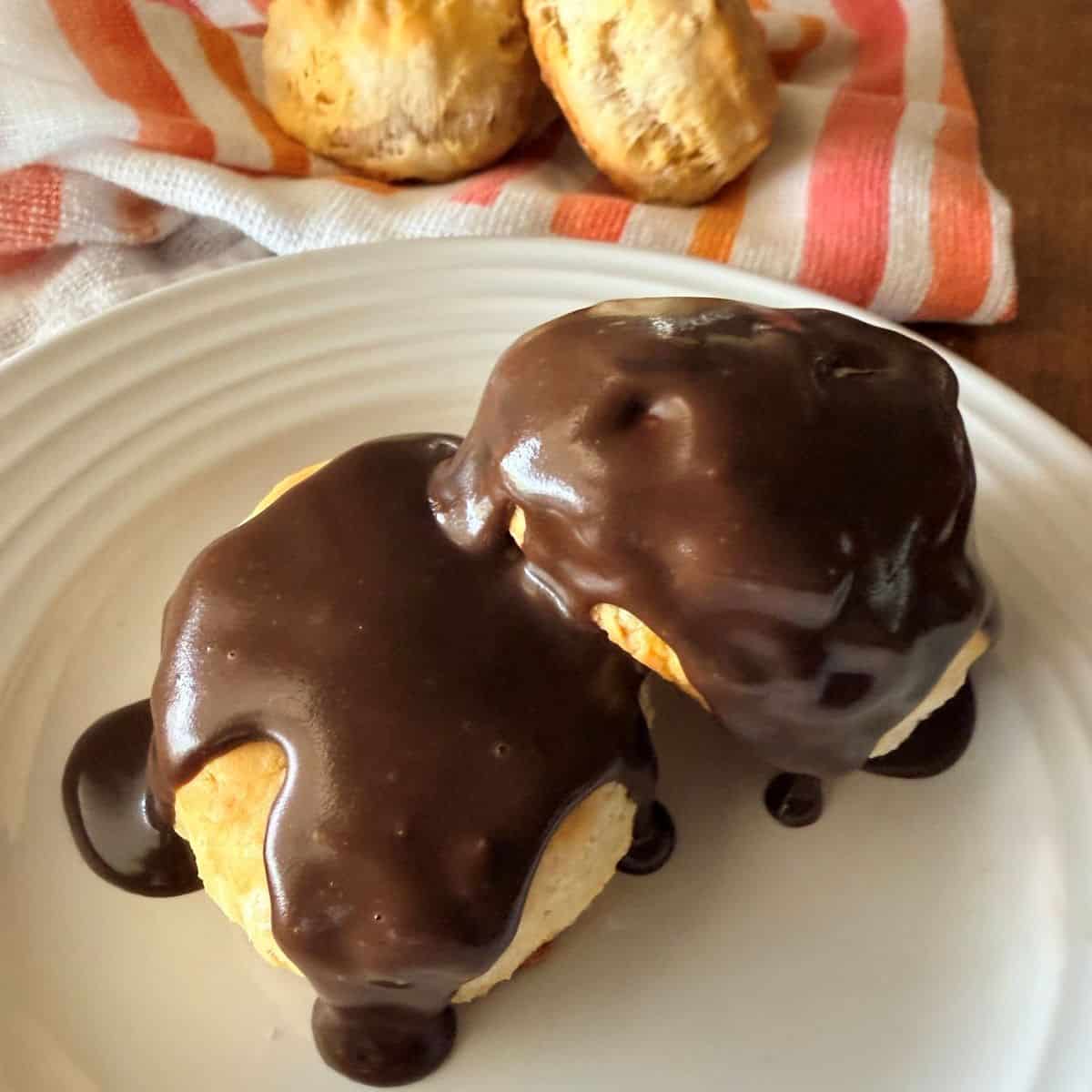 Biscuits on a plate covered in chocolate gravy – Two golden biscuits smothered in rich chocolate gravy.