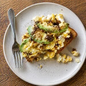 Mashed eggs on toast with sliced avocado