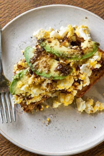 Mashed eggs on toast with sliced avocado