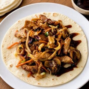 Homemade moo shu pork served in a warm flour tortilla with extra hoisin sauce.