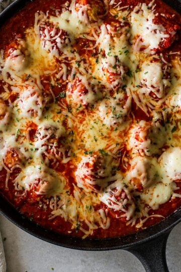 Cheesy skillet meatballs baked in homemade marinara sauce with melted mozzarella in a cast iron skillet